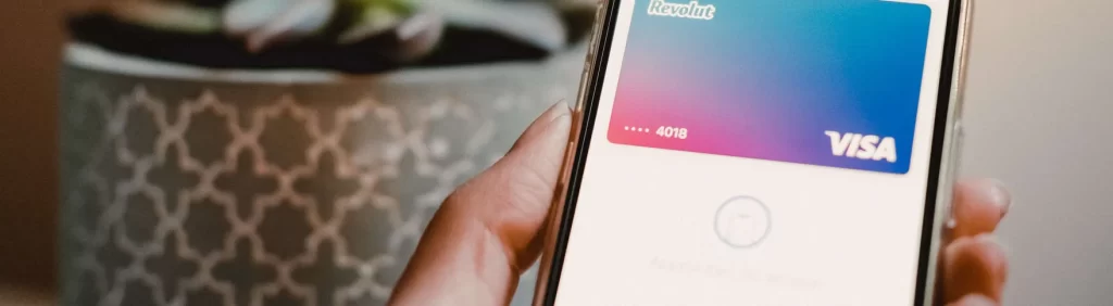 Close-up of a person's hand holding a smartphone displaying a virtual Visa credit card on the screen